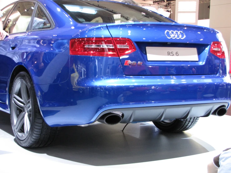 the back end of a blue car on display