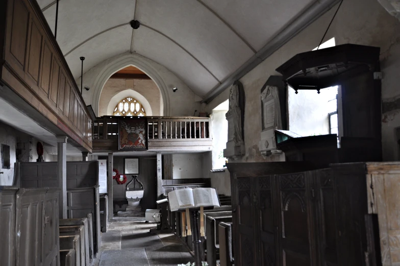 several wooden pews are in the navel of an old church