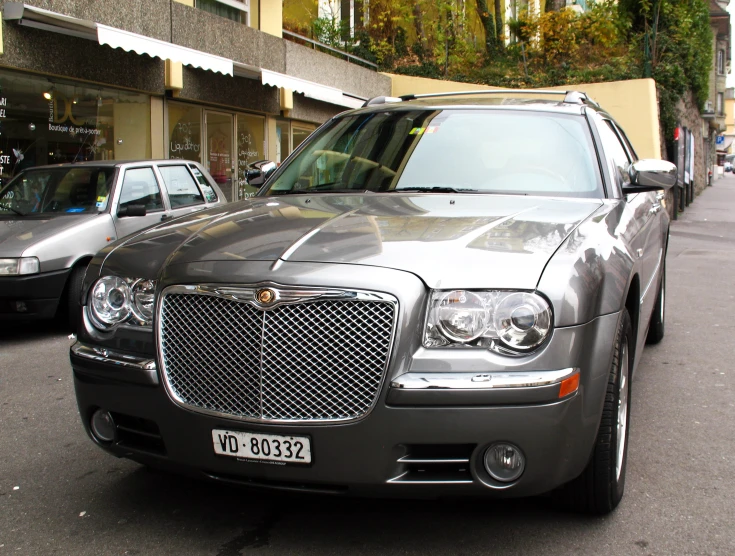 a metallic car parked near some cars on the street