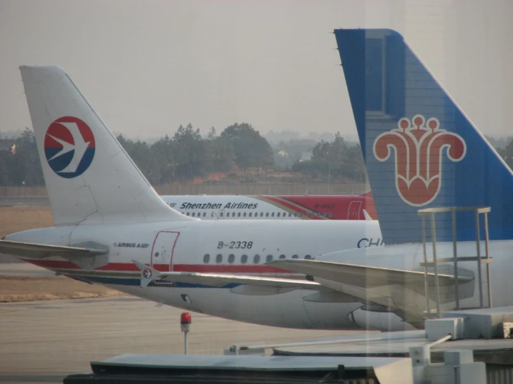 two passenger jets parked side by side on the tarmac