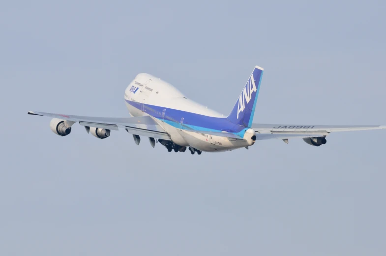 a large blue and white jet airliner flying through the air