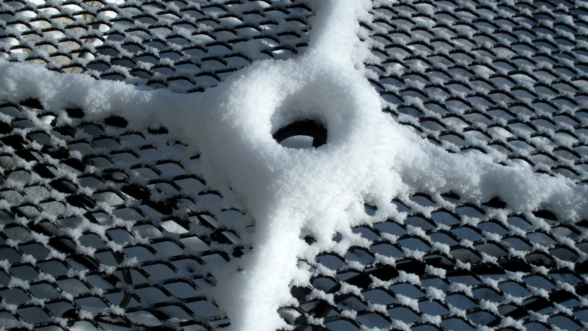 snow has been piled on the surface near a metal net