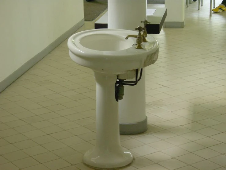 a white sink sitting under a window on a tiled floor