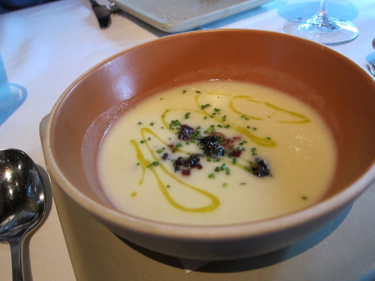 a bowl is filled with soup, garnishes and herbs