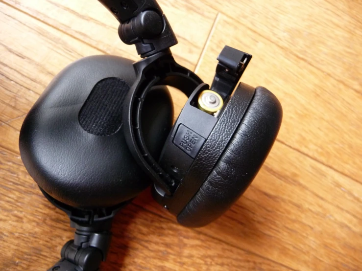 a pair of closed up headphones are on the wooden table