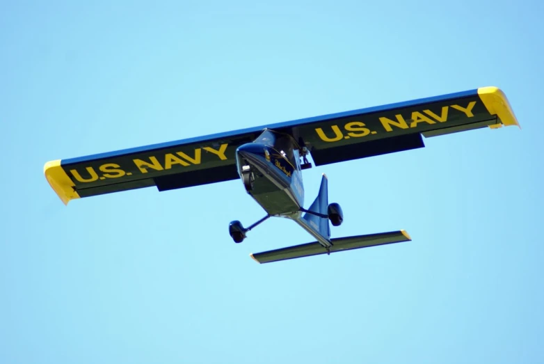 an airplane in the air carrying the us navy sign