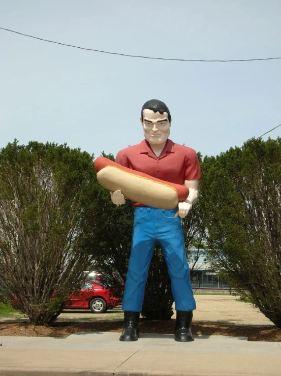 man standing on side walk with statue holding  dog