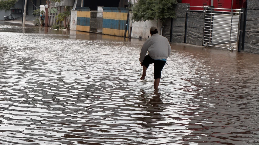 a man is wading through a flood on a street