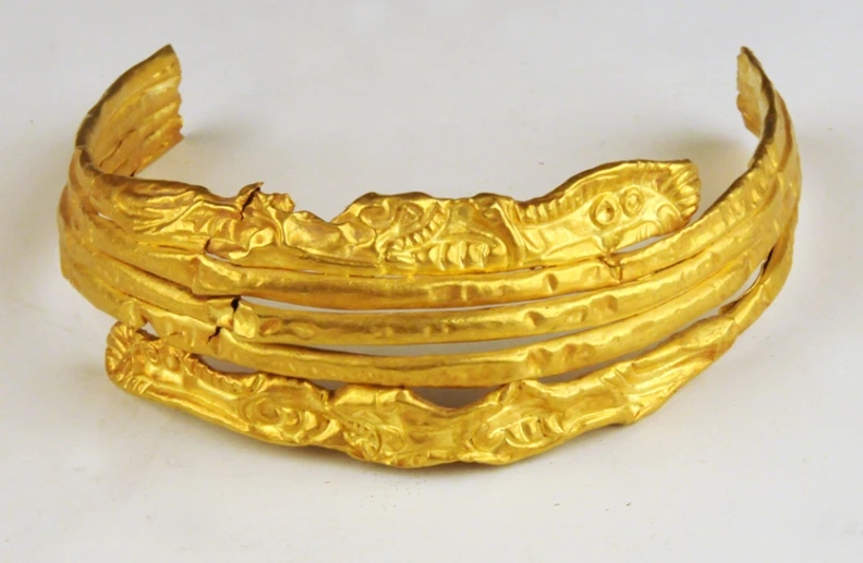 an image of gold bangles on white table