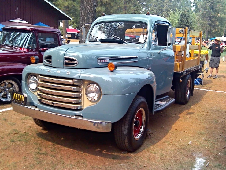 a blue pickup truck parked on top of a dirt field