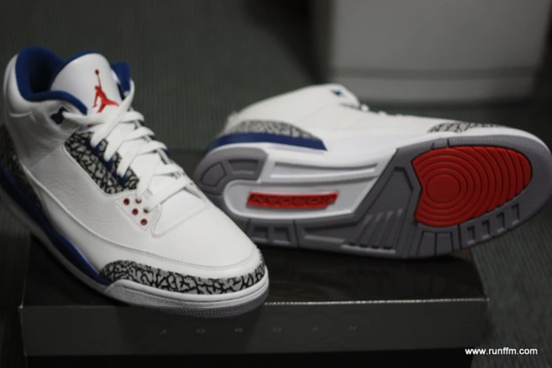 a pair of white and blue shoes sitting on a box