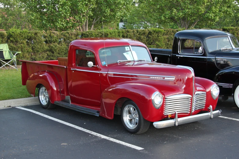 red pickup truck parked next to black one at rest