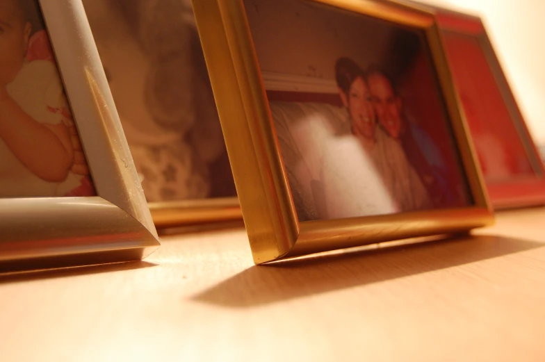 a wooden table topped with two framed pictures