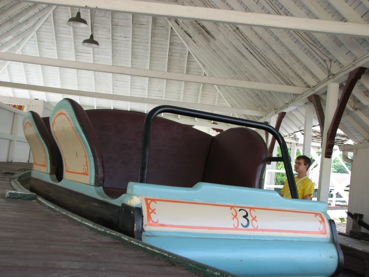 a person sitting next to some seats on a carnival ride