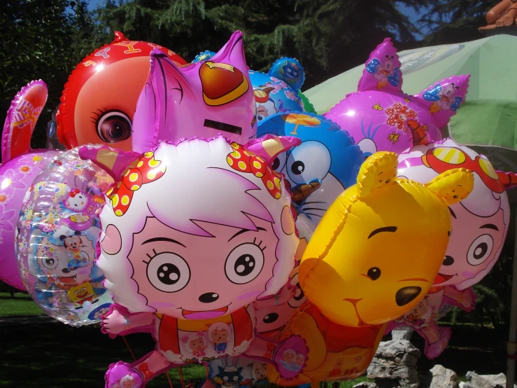 a bunch of balloons on a table in a park