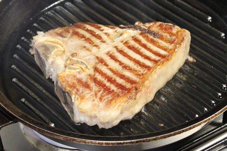 a steak is cooking on a grill in a pan