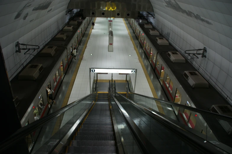 an empty escalator with some people on the opposite hand