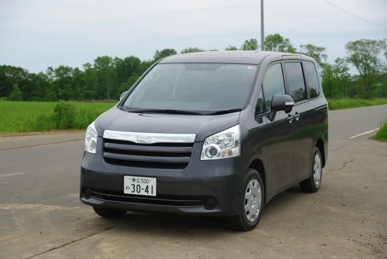 the passenger van is dark grey and black in color