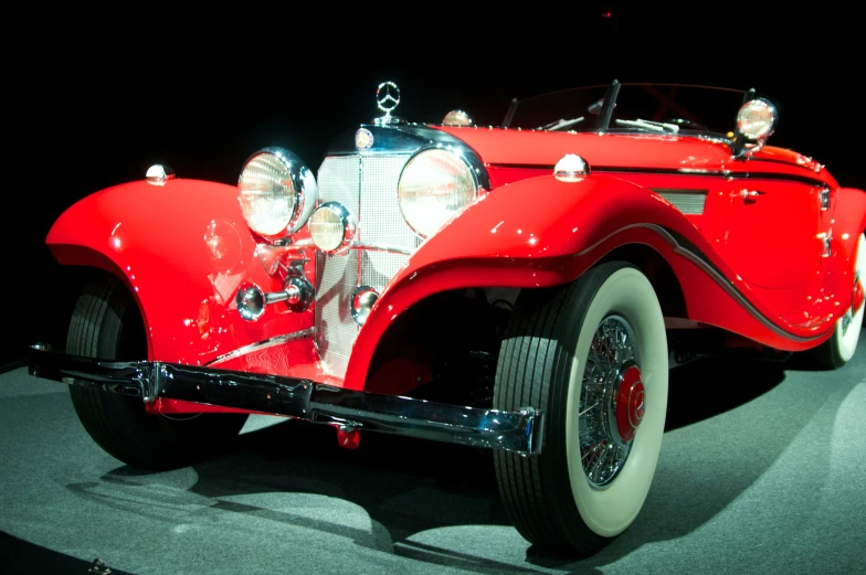 a old fashion red automobile on display at a car show