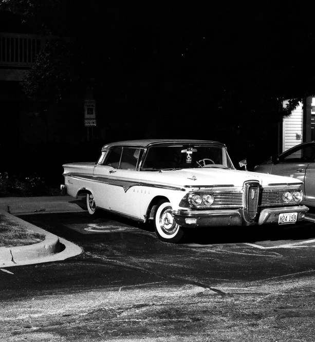 old cars parked in a driveway at night