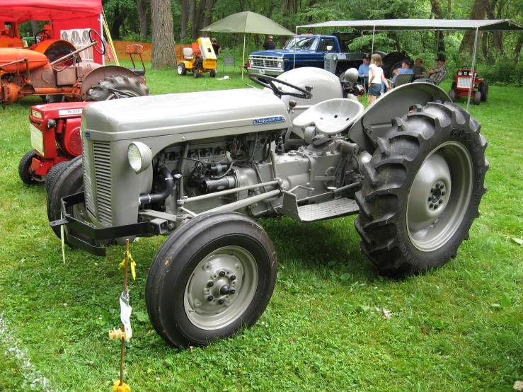 a farmallist's tractor parked on the grass at a show