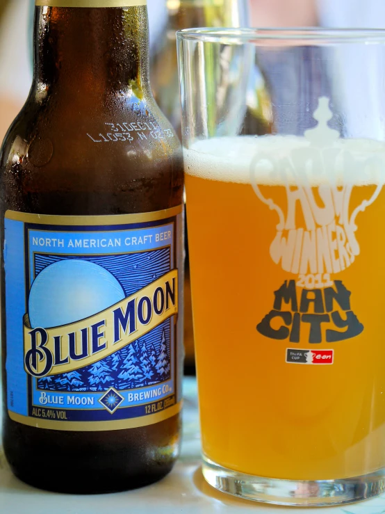 a bottle of beer and glass on top of a table