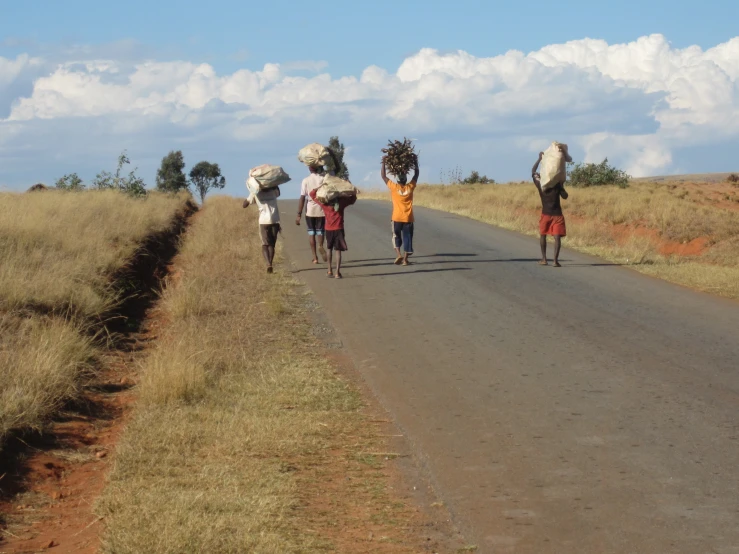 people carrying large objects down the street