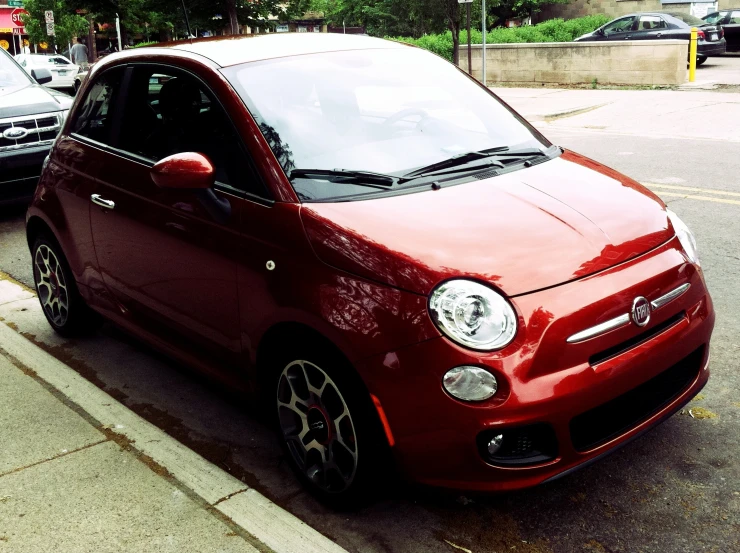 a small red car parked on a street