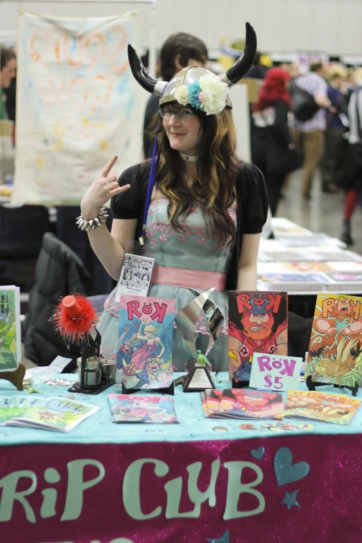 a woman in a costume and devil horns giving a peace sign