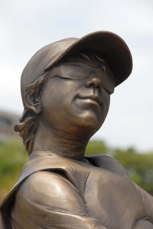a bronze sculpture is of a male baseball player