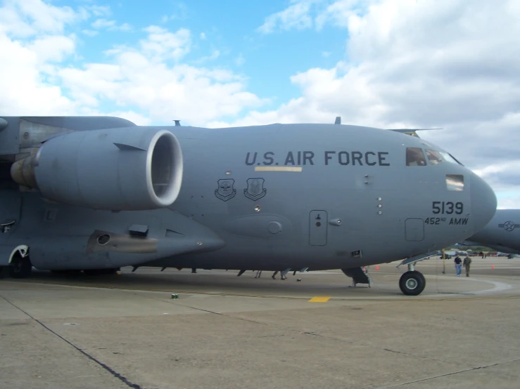 an army aircraft is on the tarmac under some clouds