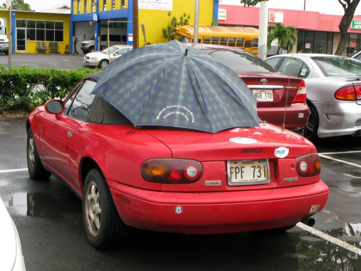 a car in the street that has an umbrella