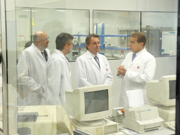 a group of men standing in a lab near computers