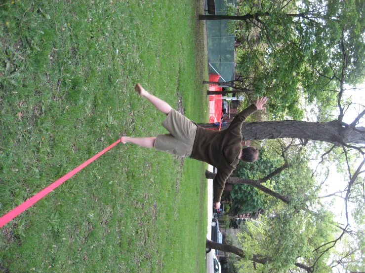 a man is jumping across a rope in the park