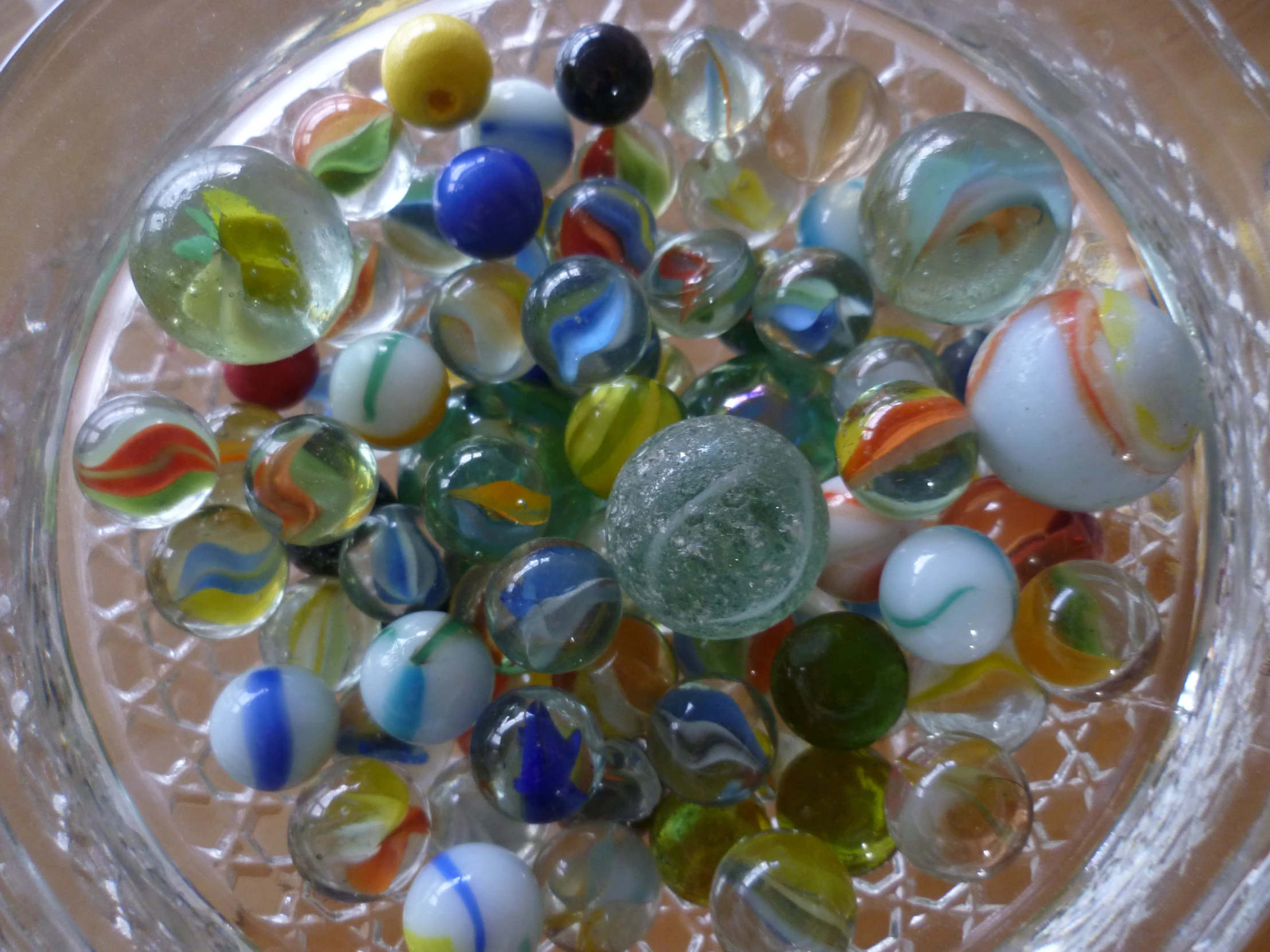 several colorful glass marbles in a glass bowl