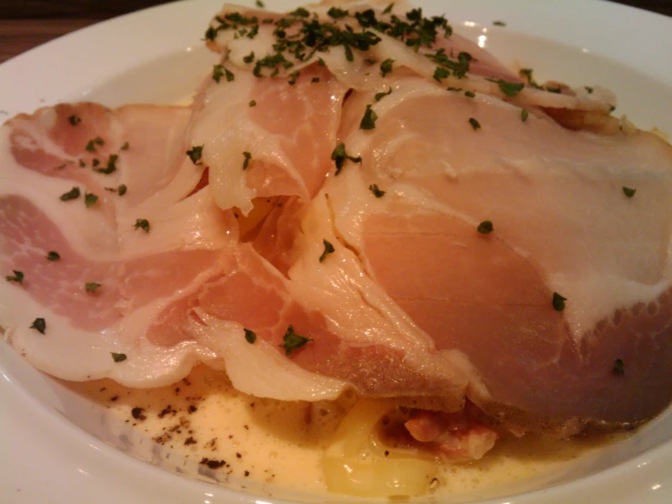 there is some meat on a plate with herbs