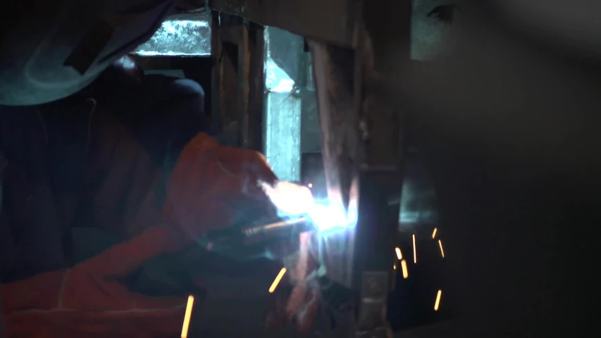 a worker is welding into the metal