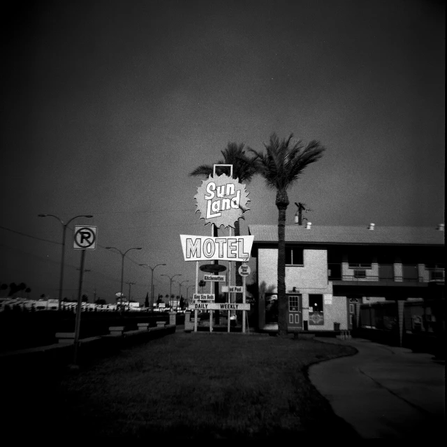 black and white pograph of a motel on the corner of road