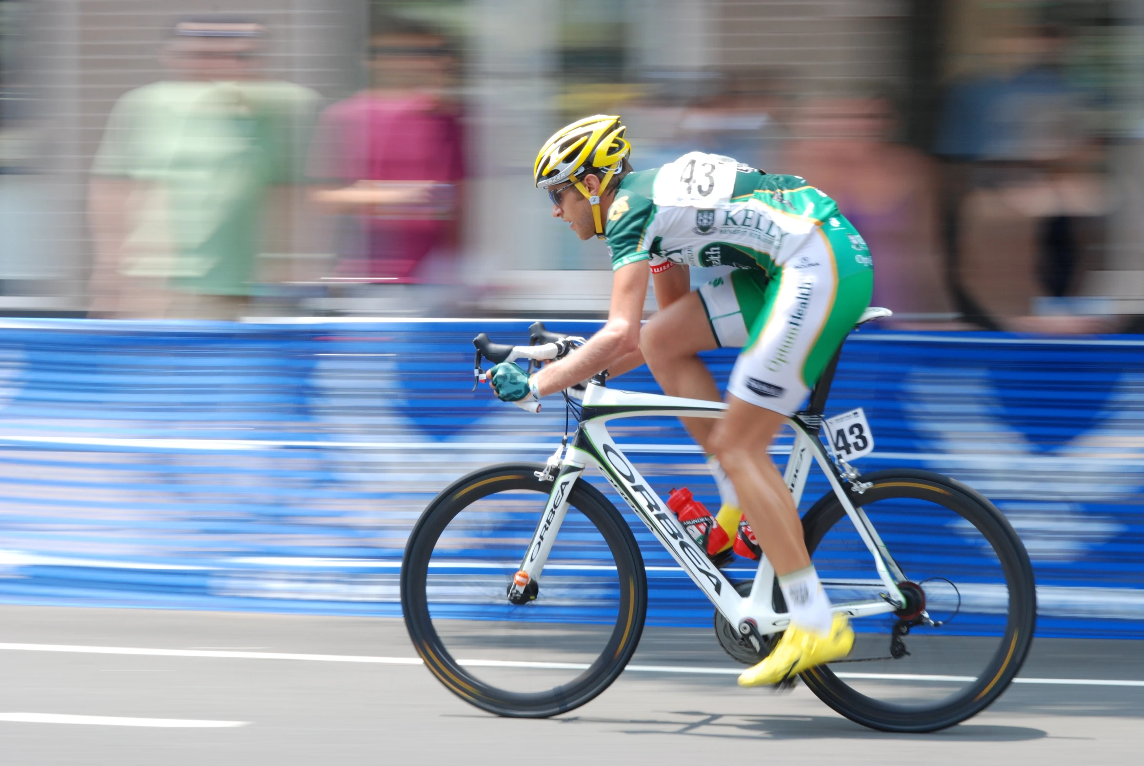 a male cyclist is wearing a white, green and yellow jersey