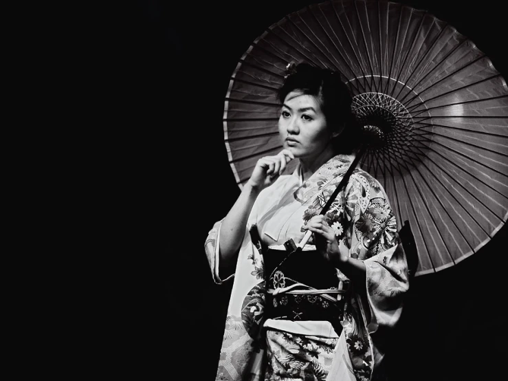 woman wearing a kimono standing in the dark