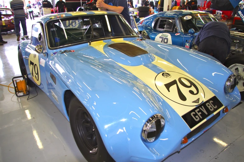 an old race car is sitting in a garage