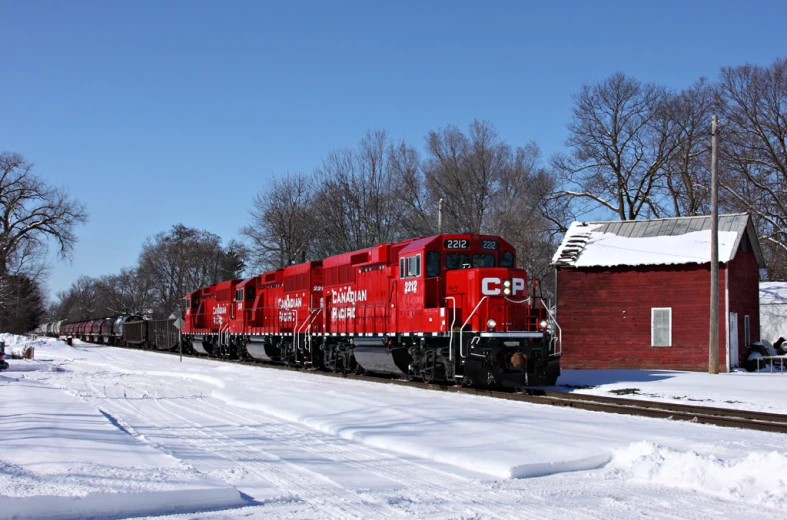 a train engine pulling passenger cars down a snow covered track