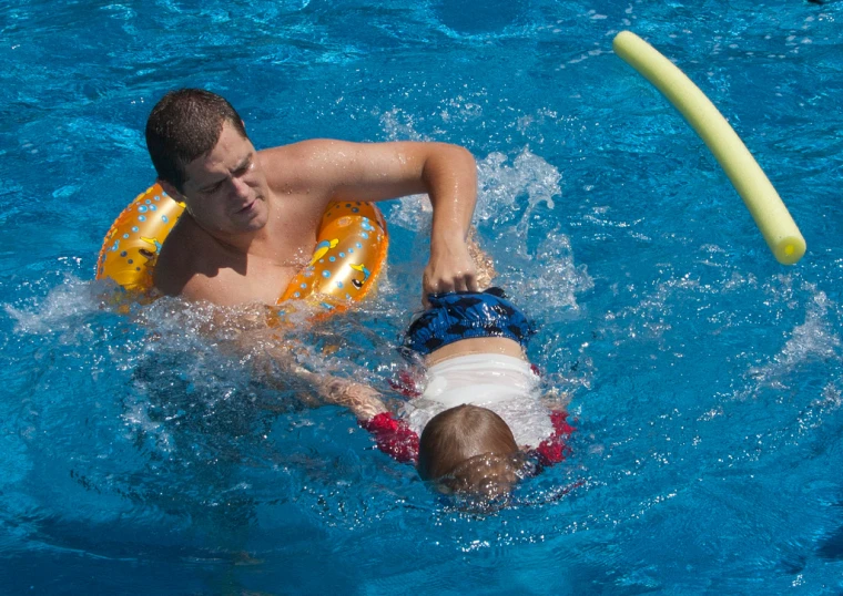 young man swimming on an inflatable boat