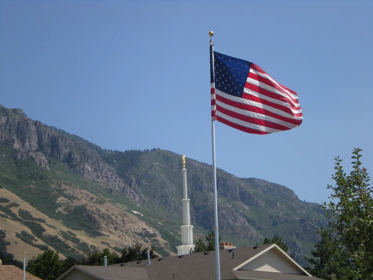 an american flag flying near a steeple in the country