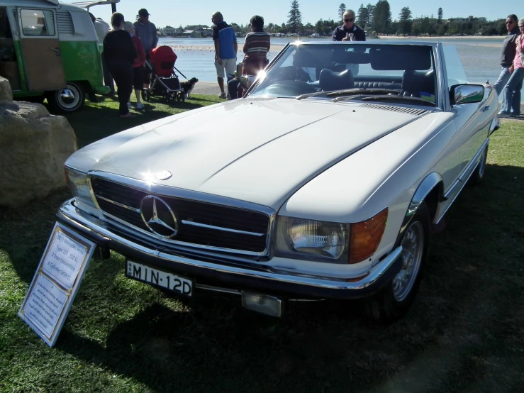 a mercedes benz with a bunch of people in the background