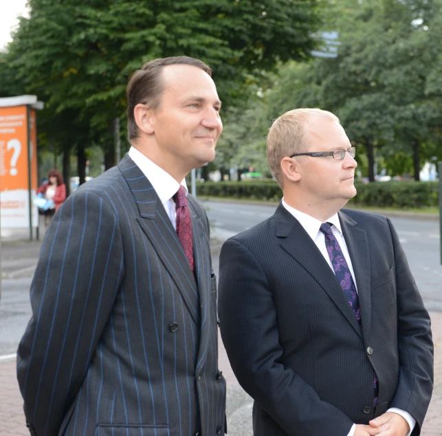 two men dressed in suits posing for a po