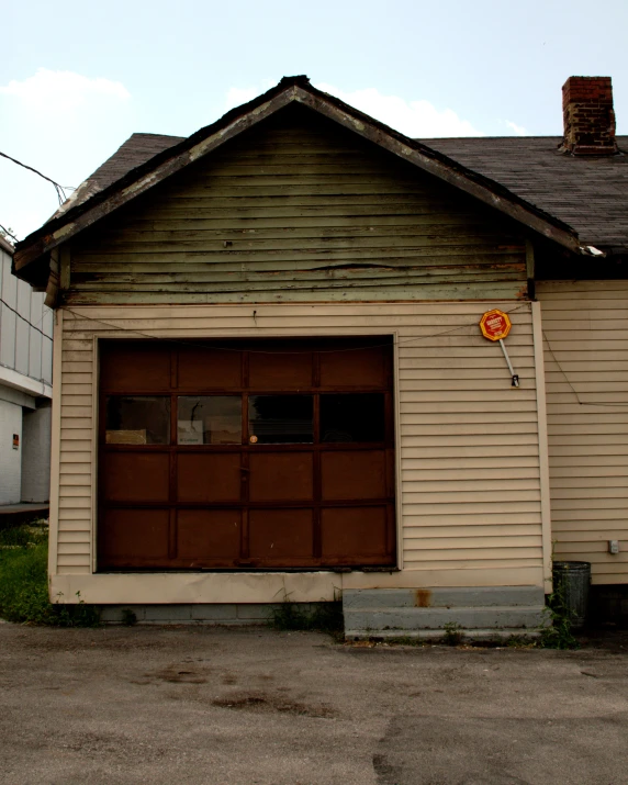 a tan house with a garage for a street sign