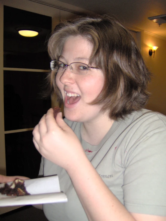 a woman taking a bite from some chocolate dessert