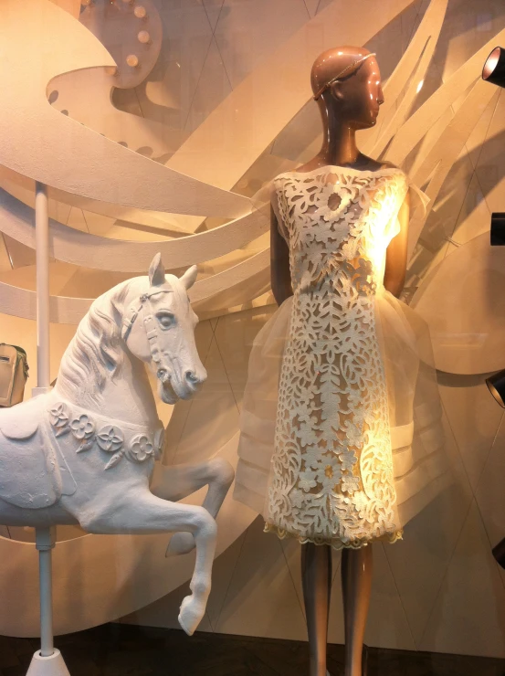 white ceramic horse in a store window next to a mannequin