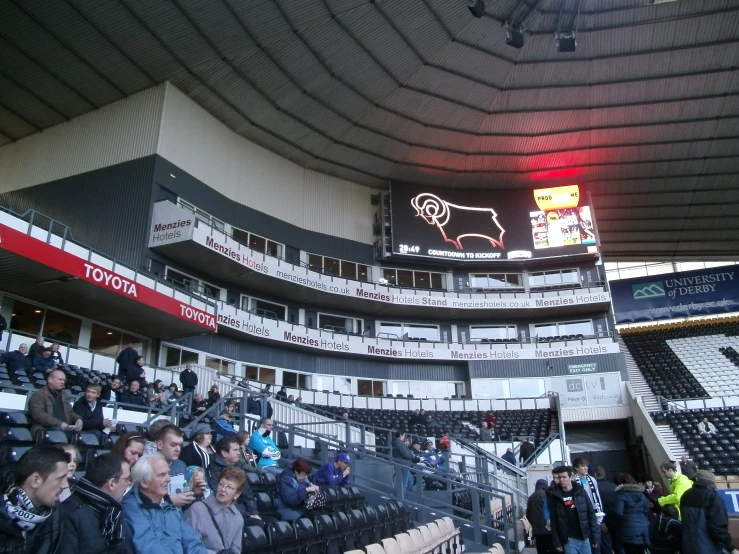 a crowd of people in a stadium with many seats and signs